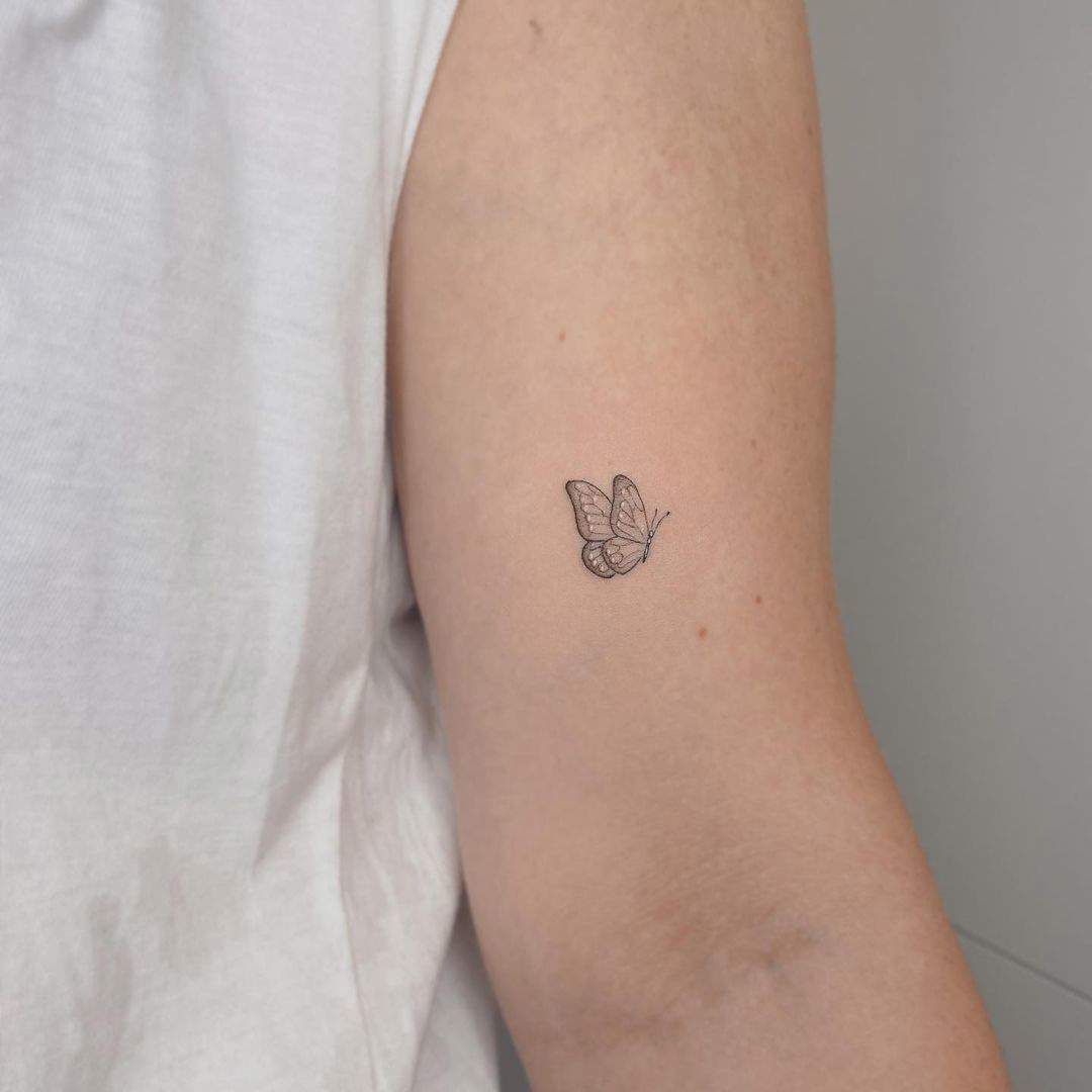 Una diminuta mariposa tatuada en el brazo