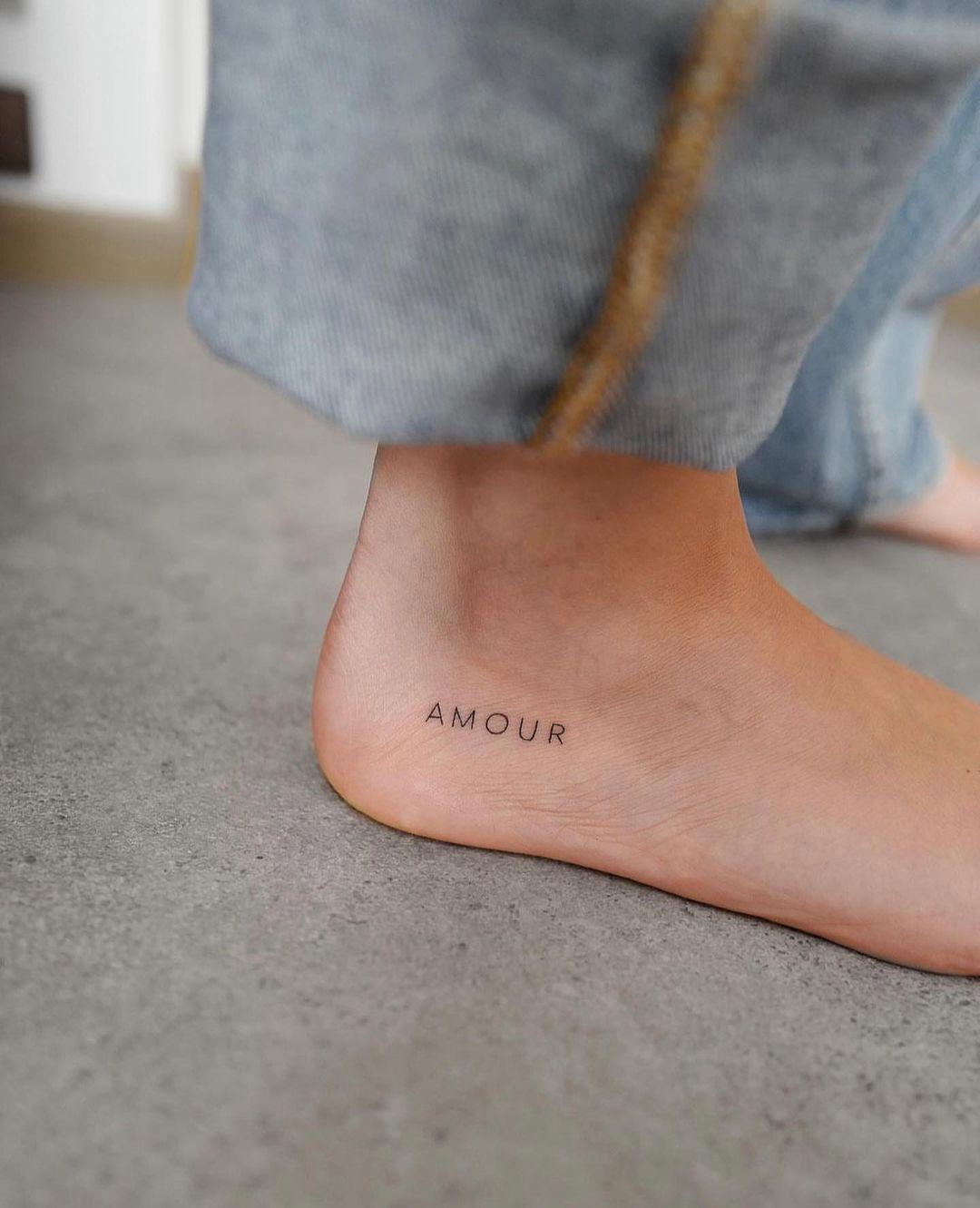 'Amour' tatuado en el pie con letra sans serif