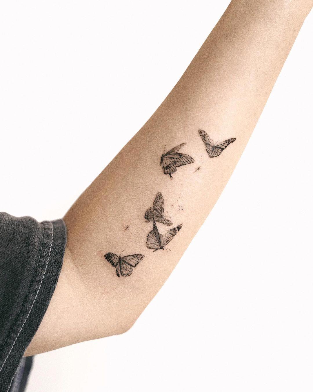 Cinco mariposas tatuadas en el brazo