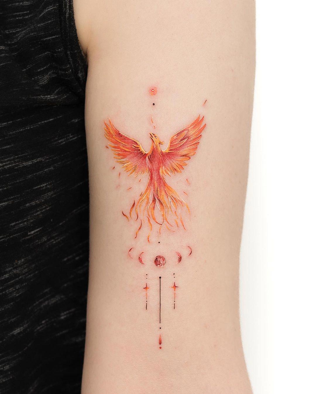 Un fénix en color tatuado en el brazo