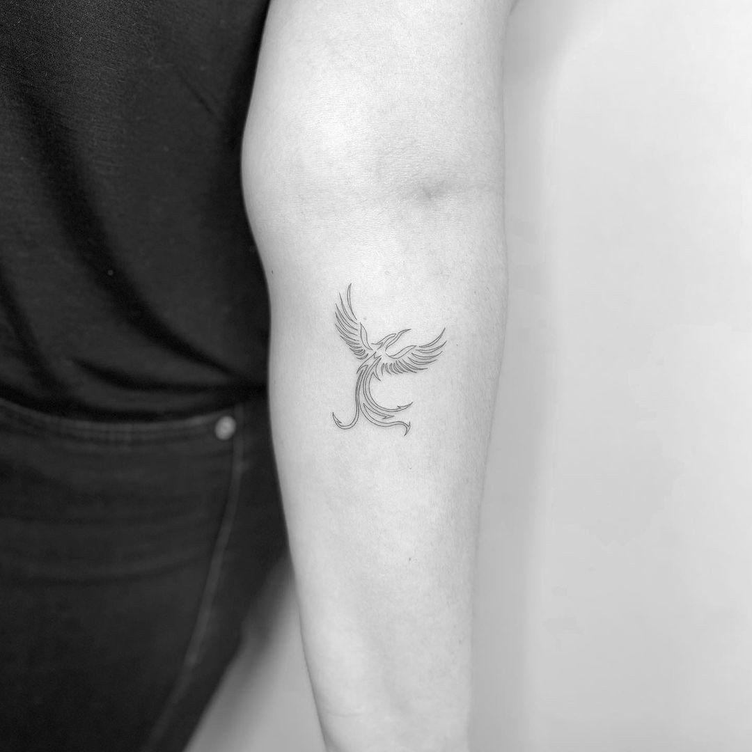 Tattoo ‘fine line’ del ave fénix en el antebrazo