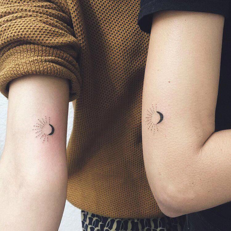 Tattoo idéntico de sol y luna en el brazo