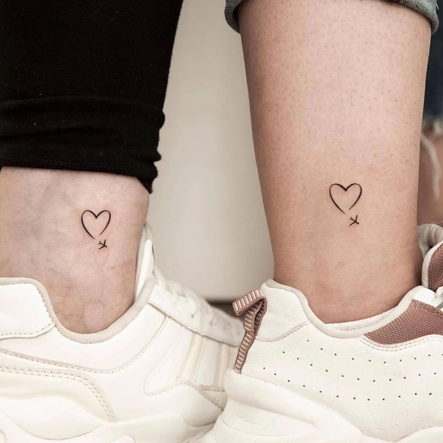 Un corazón y un avión tatuados en el tobillo