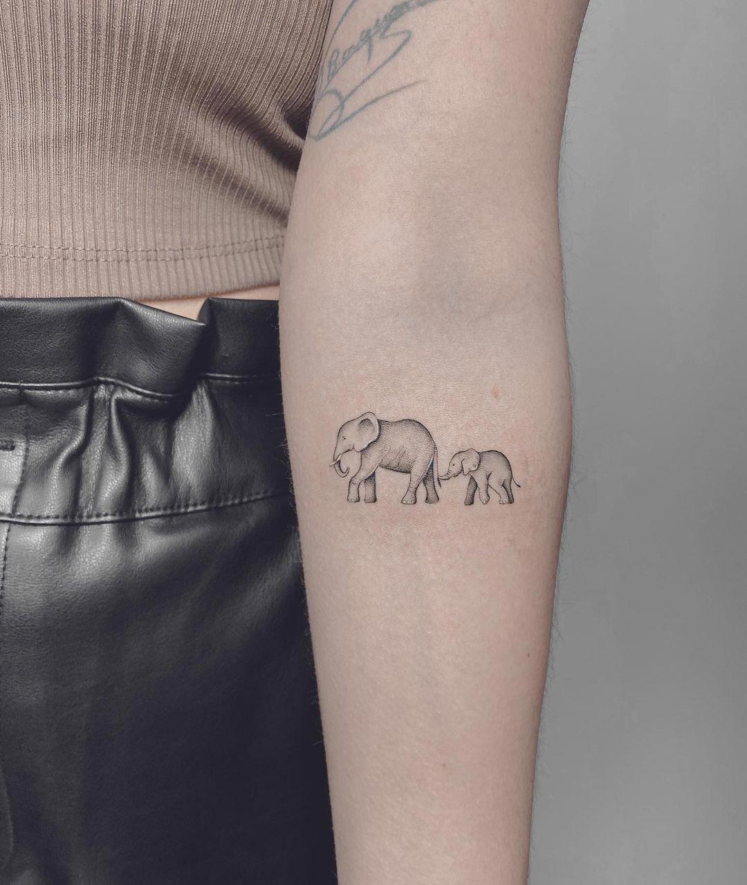 Dos elefantes tatuados en el antebrazo