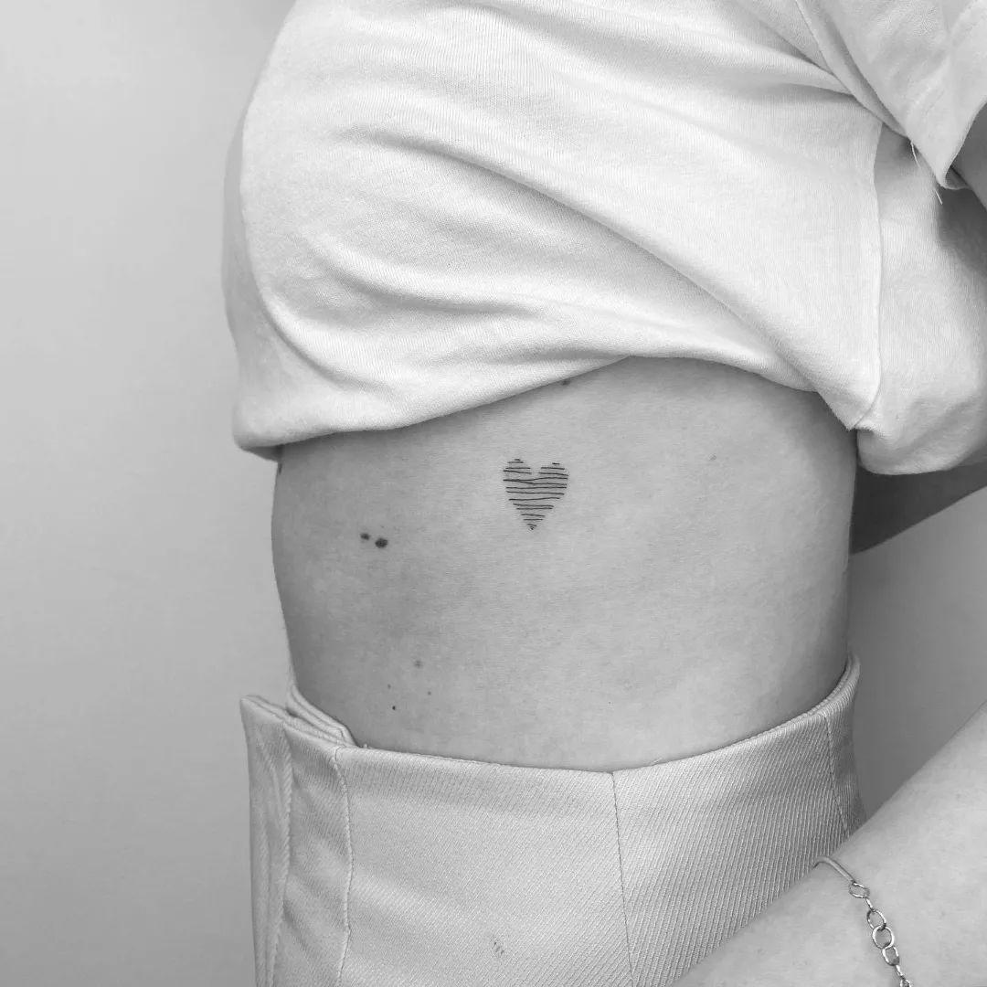 Corazón tatuado en el costado