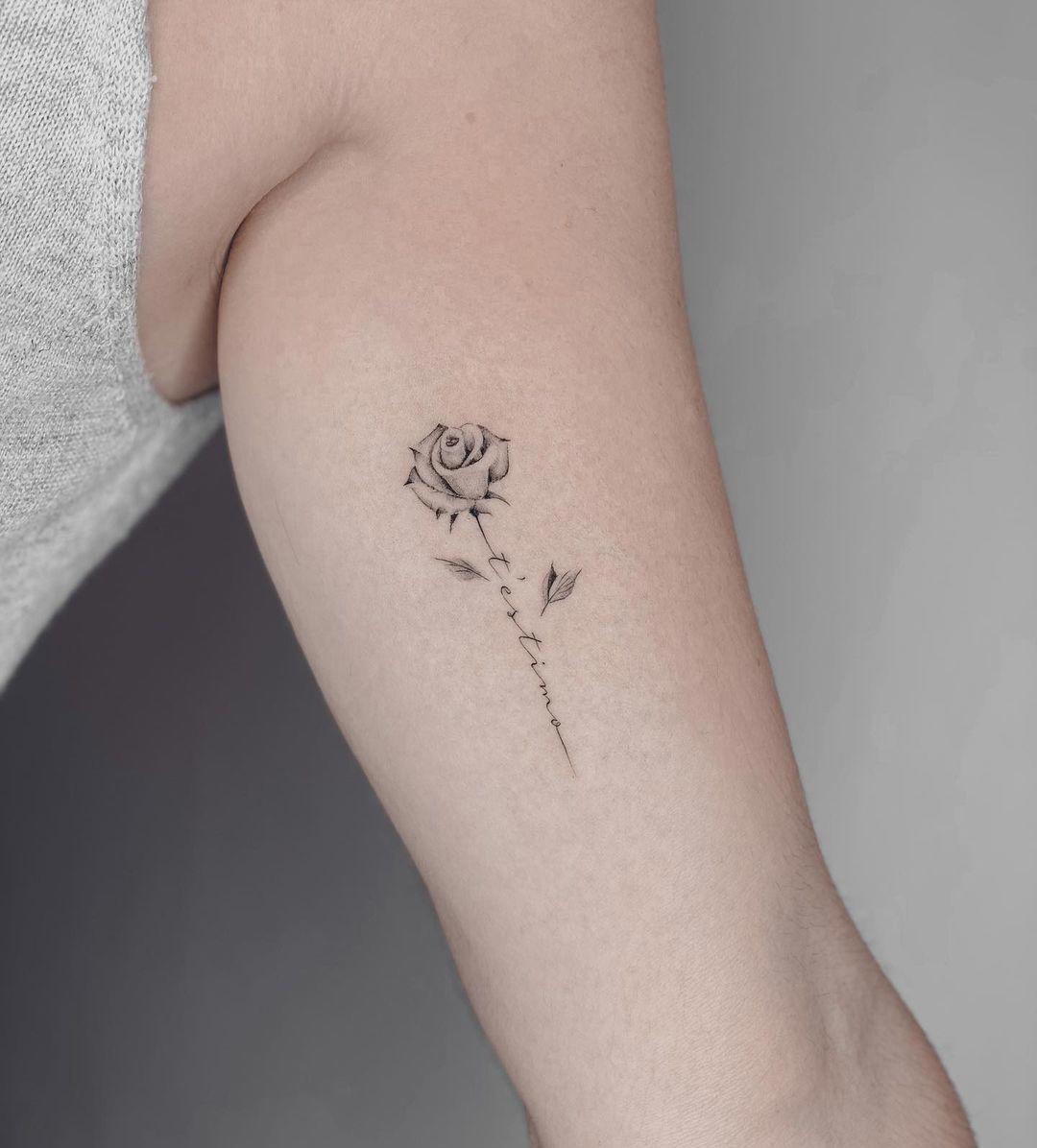 Tatuaje de flor y palabras en el antebrazo
