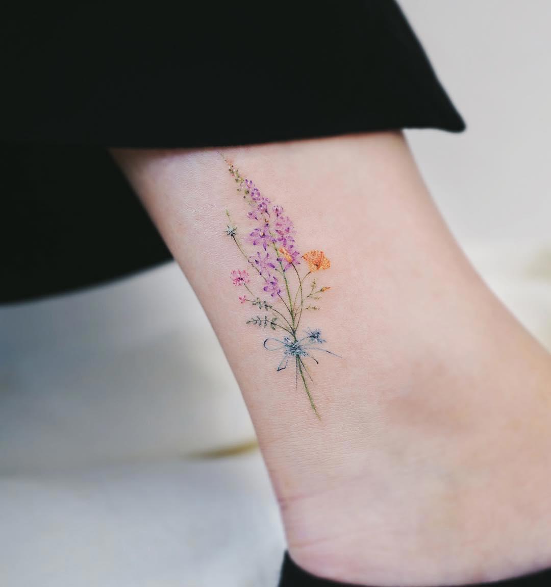 Tatuaje de flores pequeñas en el tobillo 
