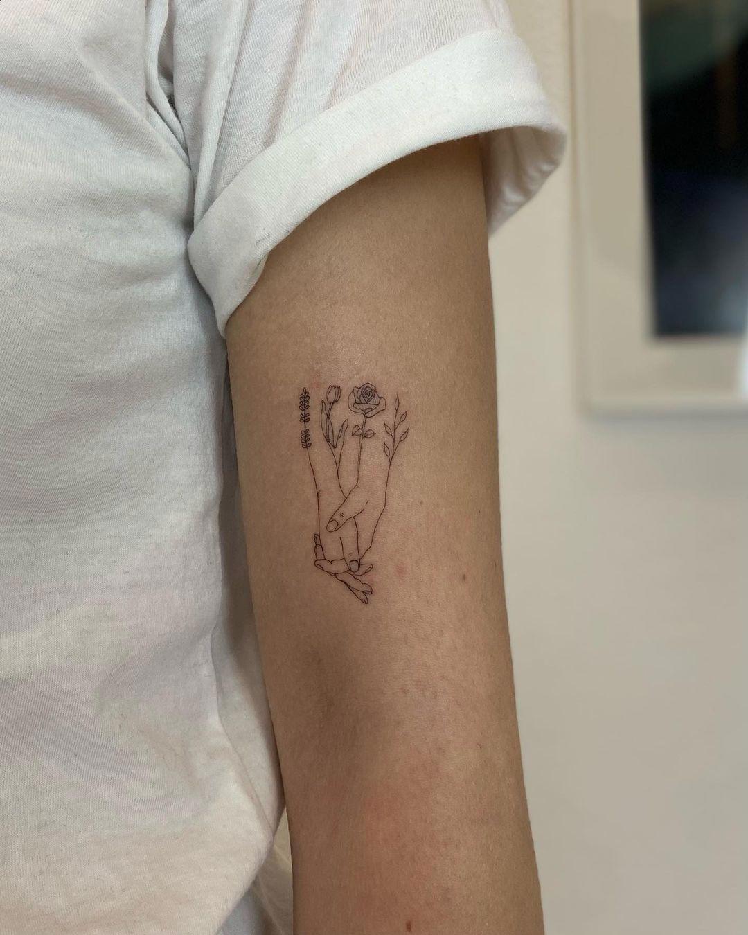 Tatuaje de flores y manos dadas