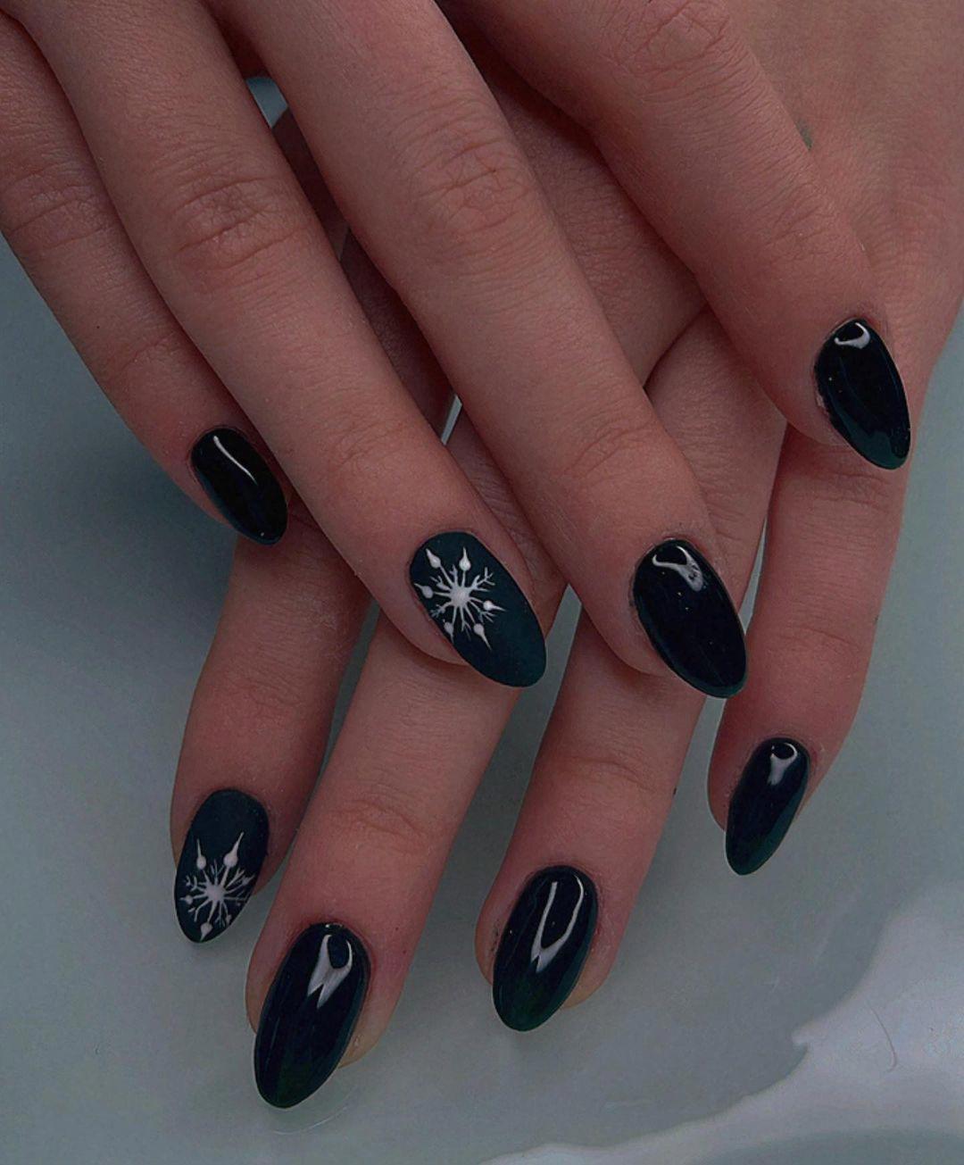 Ideas para uñas Navidad: uñas negras con copos de nive blancos