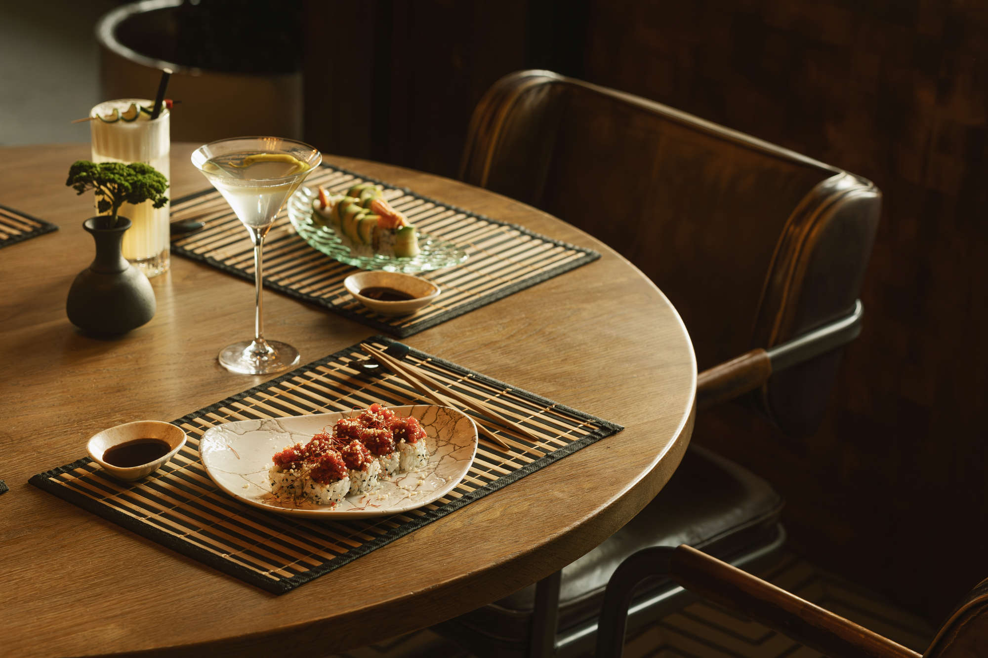 Mesa con cócteles y platos de sushi