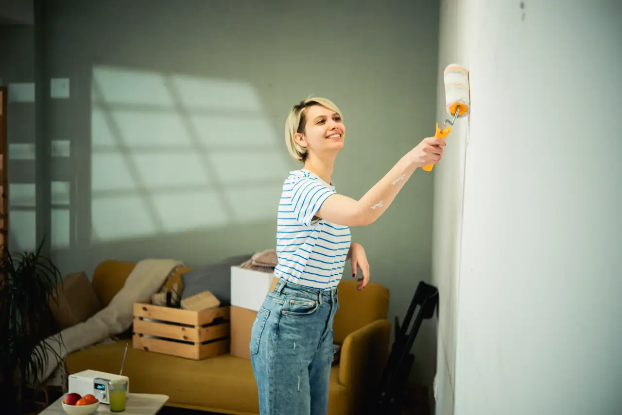 Chica pintando su casa