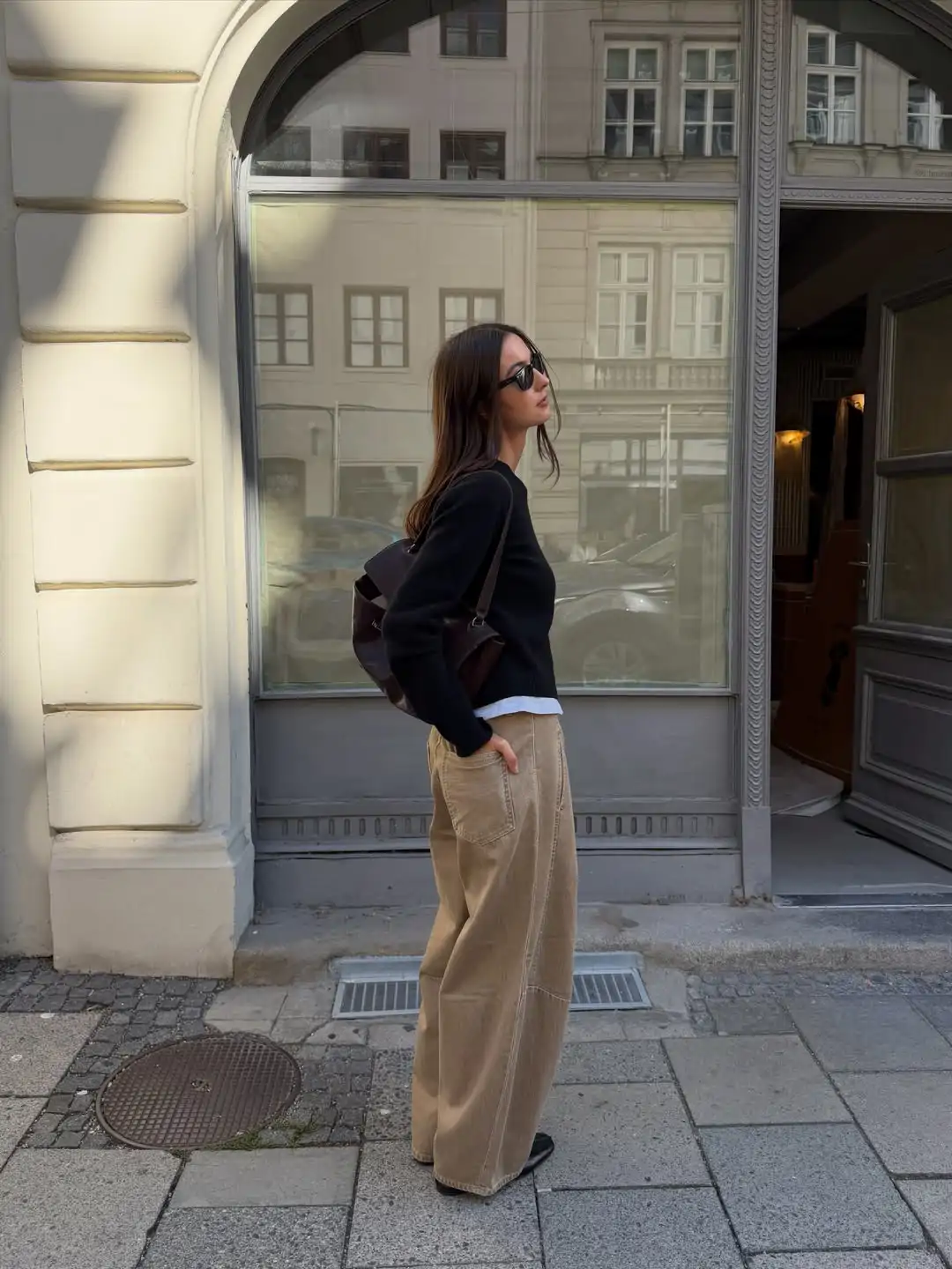 Vaqueros beige con jersey negro para un look elegante